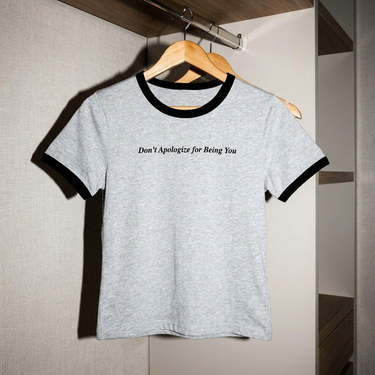 The White and Caviar Don't Apologize for Being You cropped ringer tee on a hanger, front view