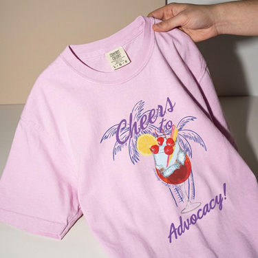Close-up of the front print on the Orchid Cheers to Advocacy Comfort Colors tee