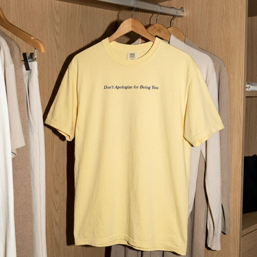 Butter Don't Apologize for Being You Comfort Colors tee shown on a hanger, front view