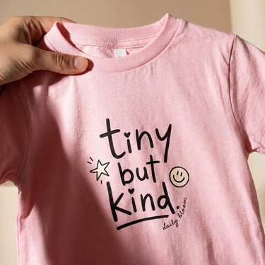 Close-up of the front print on the Pink Tiny but Kind toddler tee