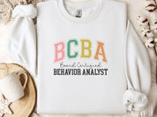 BCBA - Board Certified Behavior Analyst College Style Sweatshirt-White-Neurodiversity, ADHD & Autism Awareness & Acceptance Sweatshirt by Daily Bloom