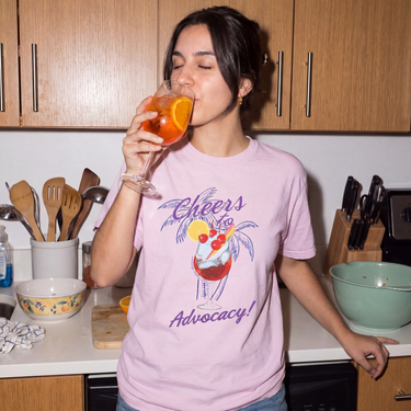 Model wearing the Orchid Cheers to Advocacy Comfort Colors tee, front print
